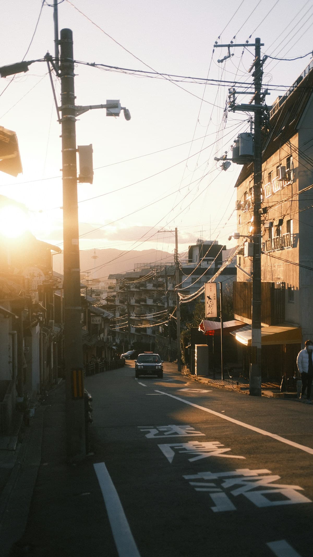 Urban street at sunset with cars and power lines — analogue travel aesthetic